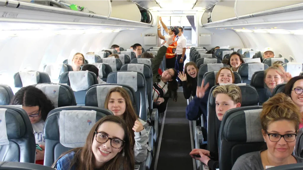 Happy student flying with ITA Airways on a discounted flight.