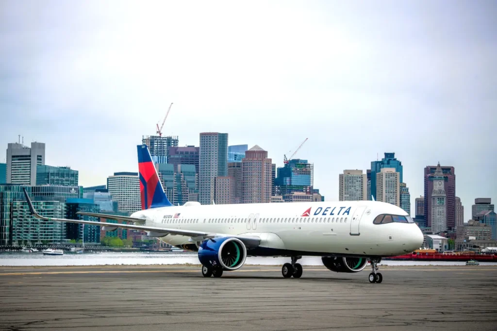 Delta plane parked with city skyline, representing nonstop flight search